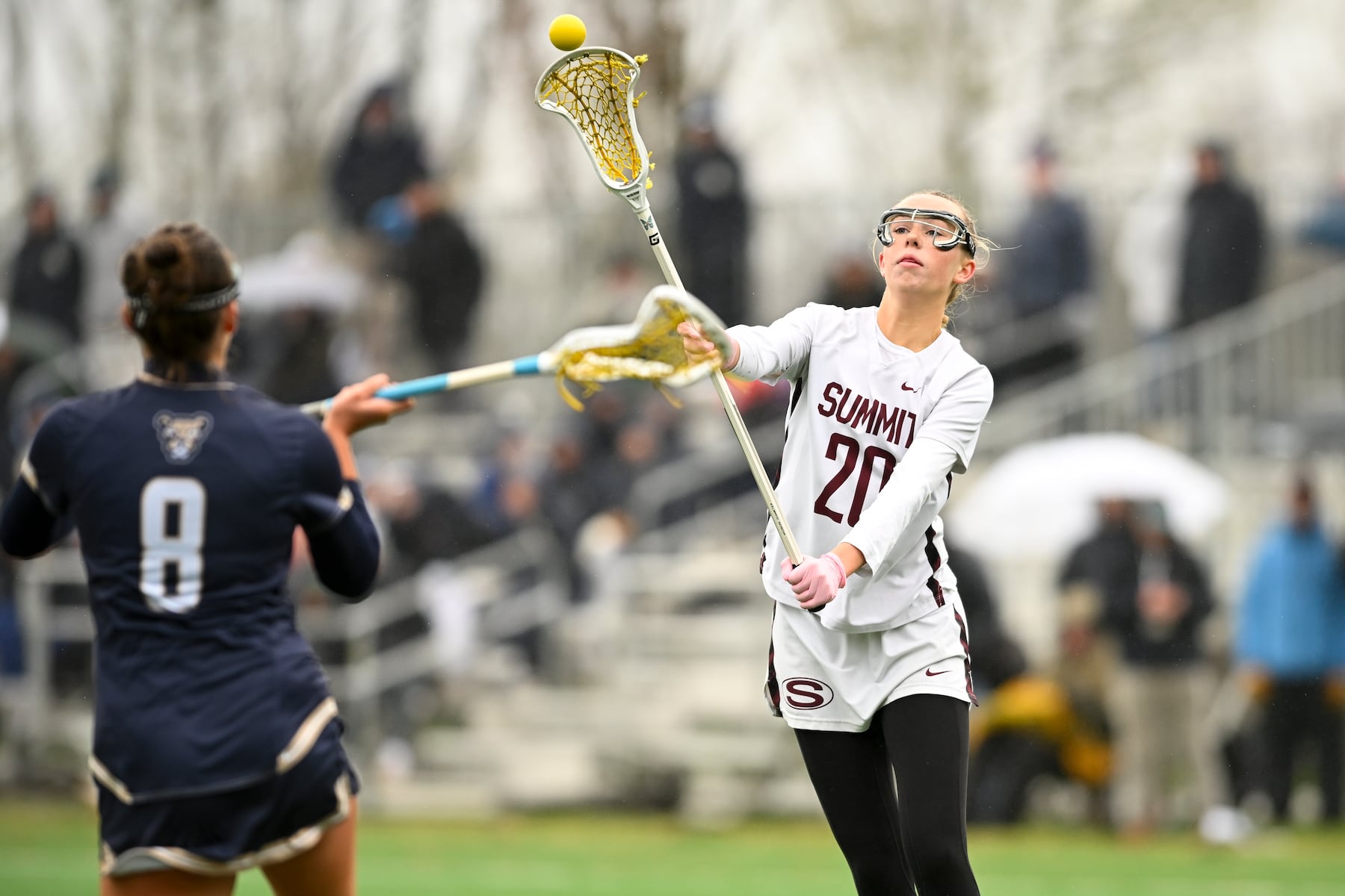 Anne Grace McGovern (20) of Summit looks to pass the ball over defender Caroline Monks (8) of Oak Knoll during the girls lacrosse game between Oak Knoll and Summit at Oak Knoll High School in Chatham, NJ on Saturday, April 12, 2025.