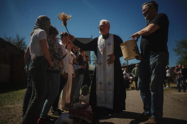 Father Henadii blesses Easter baskets during celebration of Orthodox Easter...