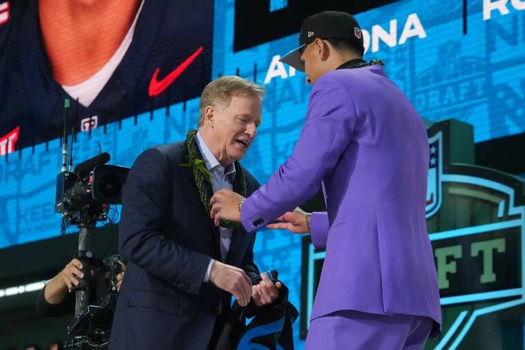 KIRBY LEE / IMAGN IMAGES
Arizona Wildcats Tetairoa McMillan gives a lei to NFL commissioner Roger Goodell after the Waimanalo-born wide receiver was chosen eighth overall by the Carolina Panthers in the NFL Draft at Lambeau Field today.
