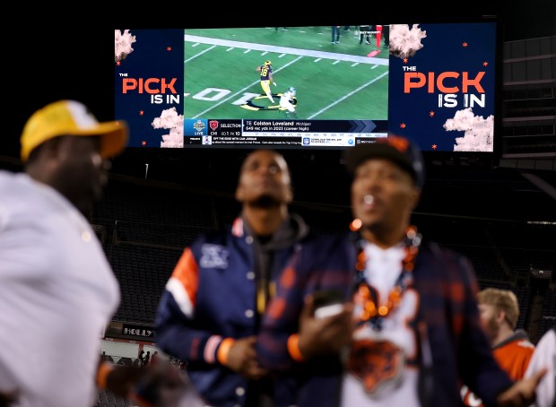 Fans attending a Bears draft party at Soldier Field watch...