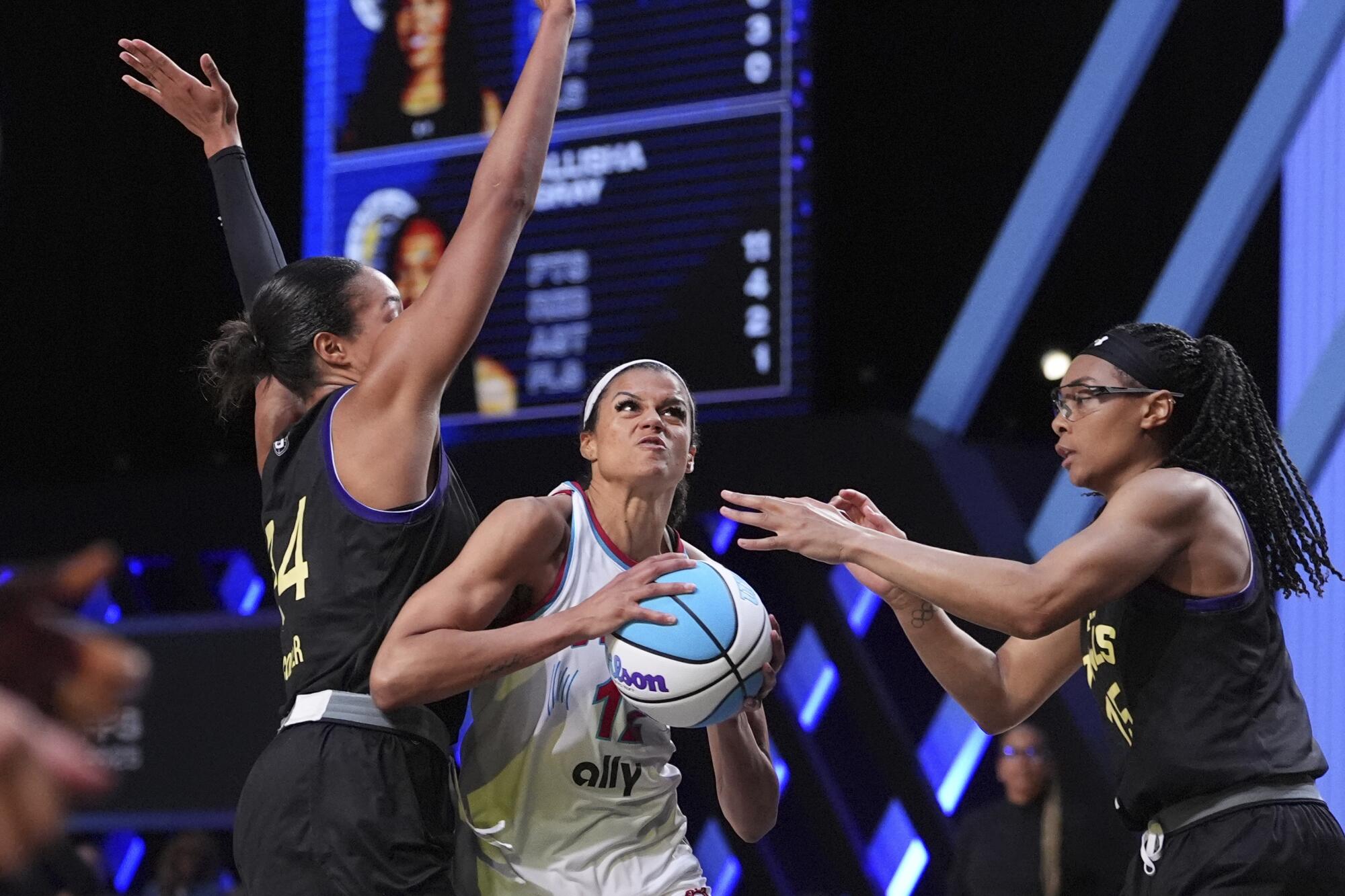 Vinyl wing Rae Burrell holds the ball and tries to split between Owls forward Napheesa Collier and wing Allisha Gray