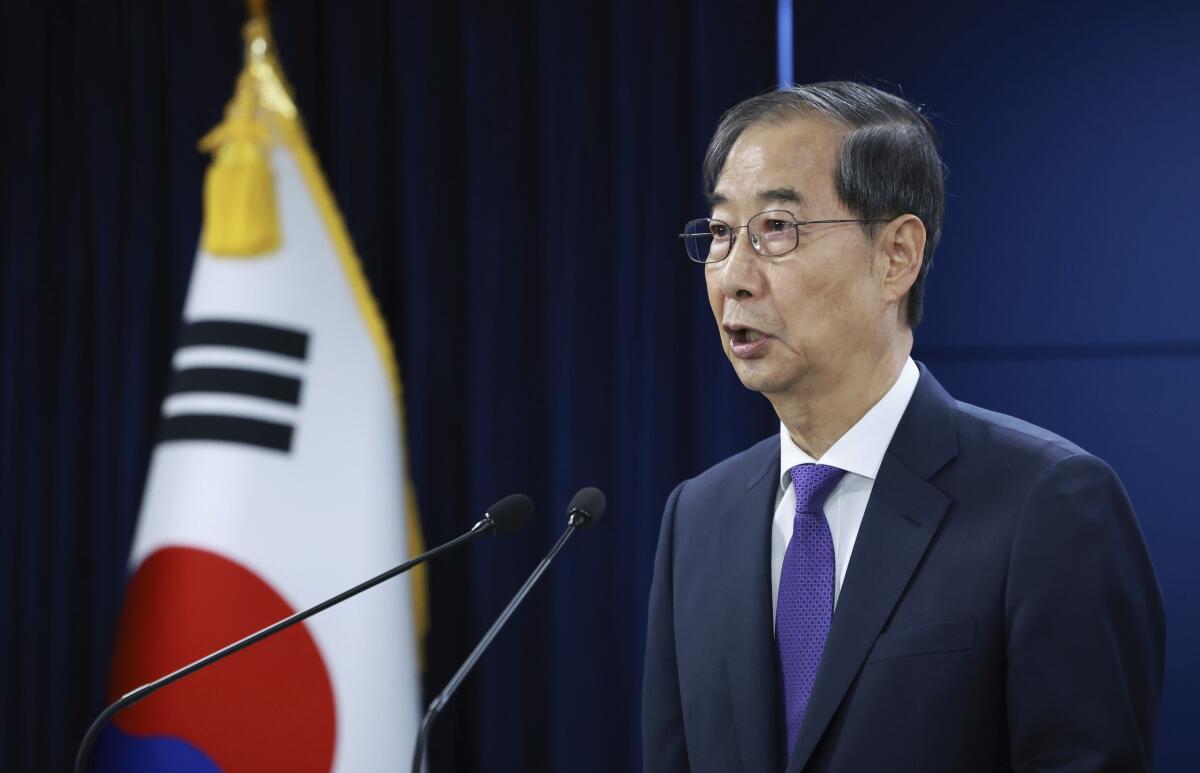 South Korean acting President Han Duck-soo speaks in Seoul with a flag nearby