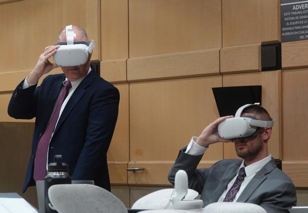 Defense attorneys Ken and Jason Padowitz watch a virtual reality...