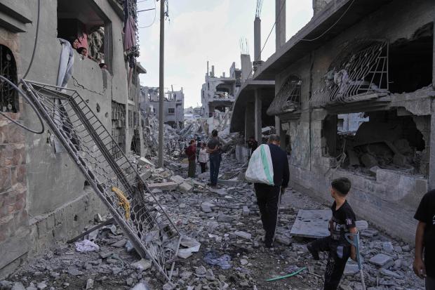 Palestinians inspect the rubble of homes destroyed by Israeli airstrikes...