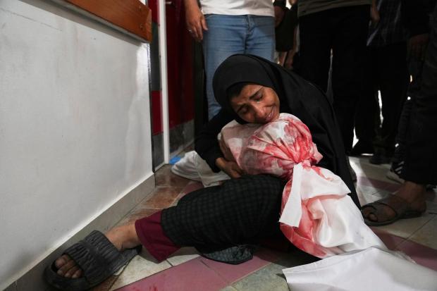 A Palestinian woman mourns her son, killed in an Israeli...