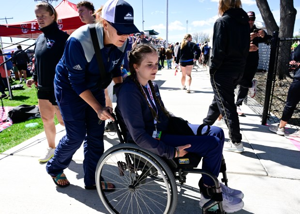 Platte Valley High School coach Julie Thomas pushes junior paralympic athlete Leeandra Natotschi through traffic at the State Track and Field Championships at Jeffco Stadium in Lakewood, Colorado, on Friday, May 16, 2025. (Photo by Andy Cross/The Denver Post)