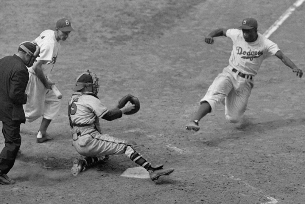 Brooklyn Dodgers star Jackie Robinson steals home as Boston Braves catcher Bill Salkeld is thro ...