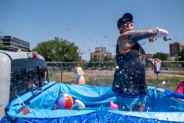 Sherry Davis splashes water from her truck bed pool to...