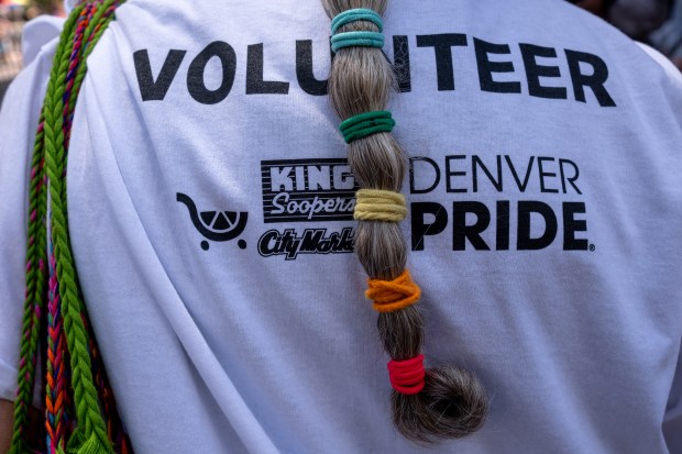 A volunteer’s hair is done with rainbow elastics at the...