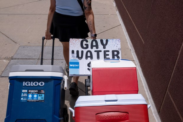 Vendors selling “gay water” leave the Denver Pride Parade area...