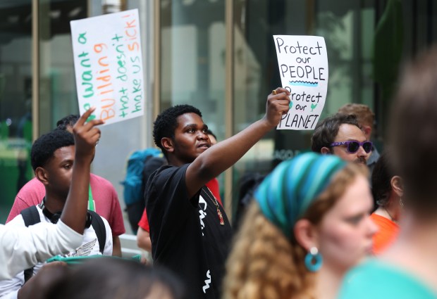 Zion Richards, a Curie High School senior, holds a sign reading "Protect our People, Protect our Planet" while attending a Chicago Teachers Union news conference outside of Chicago Public Schools headquarters prior to a CPS monthly board meeting on June 26, 2025. (Chris Sweda/Chicago Tribune)