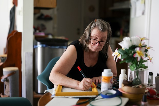 Kristina Lewis, who relies on Medicaid, paints a craft project in her apartment in Alsip on June 27, 2025. (Eileen T. Meslar/Chicago Tribune)