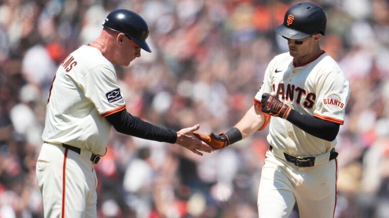 San Francisco Giants' Mike Yastrzemski, right, is congratulated by third base coach Matt Williams after hitting a home run during the fifth inning of a baseball game against the Boston Red Sox in San Francisco, Sunday, June 22, 2025.