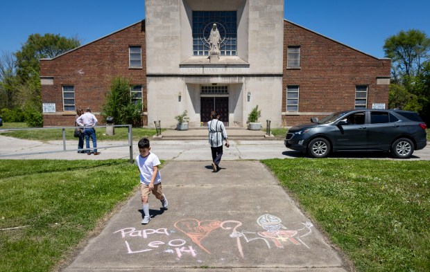 Chalk messages are left for new Pope Leo XIV outside his former St. Mary of the Assumption Church on May 11, 2025, in the Far South Side's Riverdale neighborhood. (Brian Cassella/Chicago Tribune)