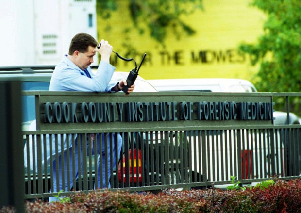 A worker at the Cook County medical examiner's office takes...