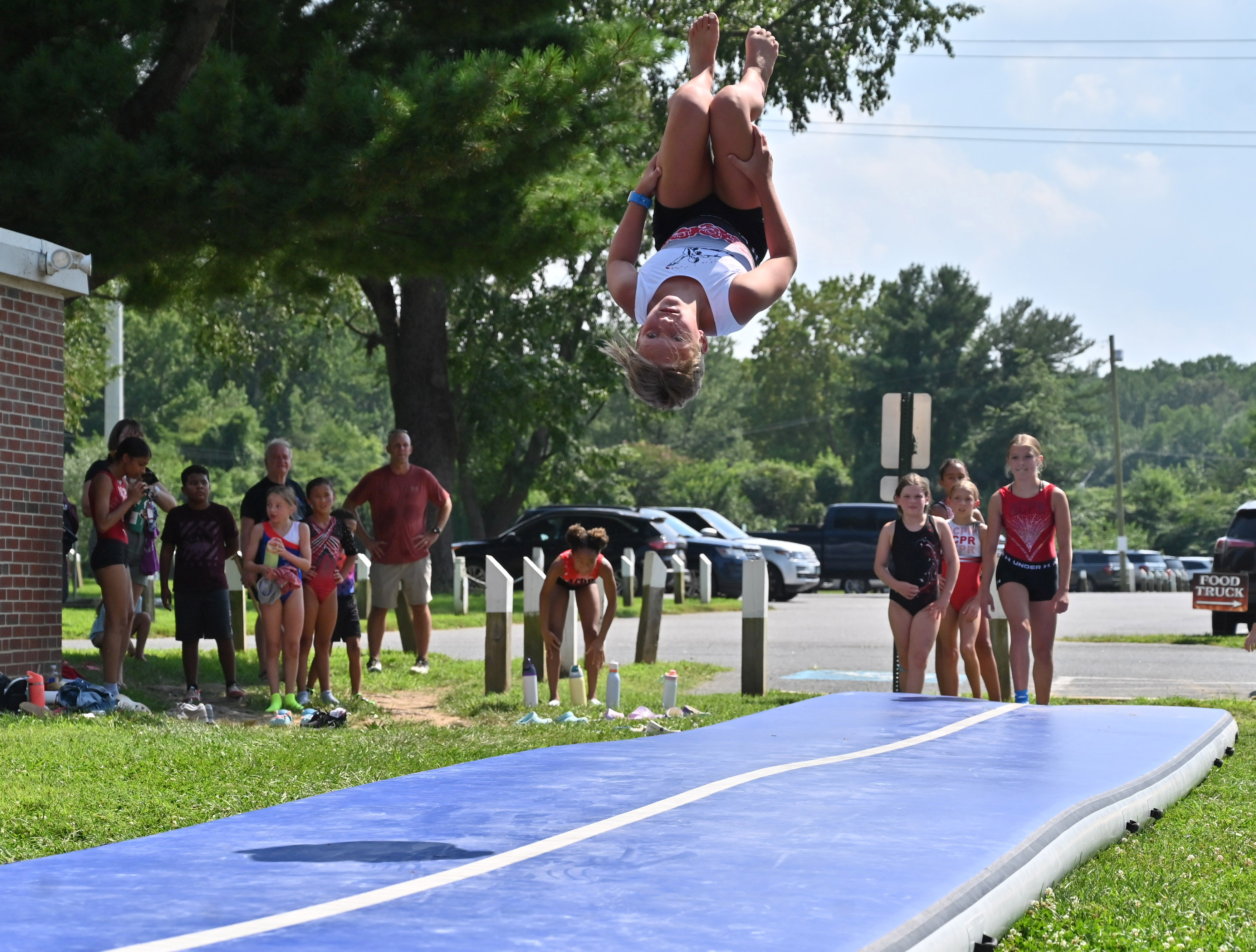 Sadie Cosenza flips in the air as she performs a demonstration with ACPR Gymnastics during Harford County Parks and Recreation Day at Flying Point Park on Friday. (Brian Krista/Staff)