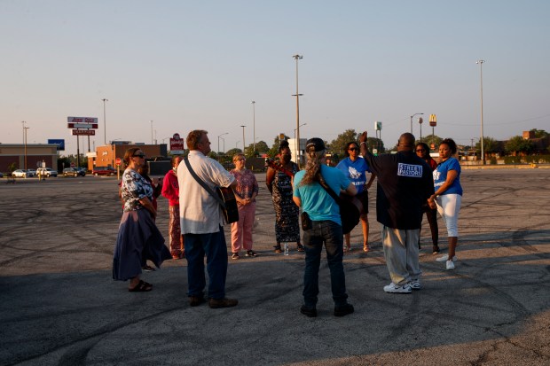 People gather for a prayer vigil against violence organized by the Rev. Donovan Price in a Chicago parking lot near West 87th Street and the Dan Ryan Expressway after the Fourth of July holiday weekend, July 5, 2021. (Armando L. Sanchez/Chicago Tribune)