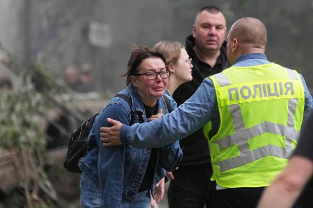 Women react outside a destroyed apartment building after a Russian missile attack in Kyiv, Ukraine,