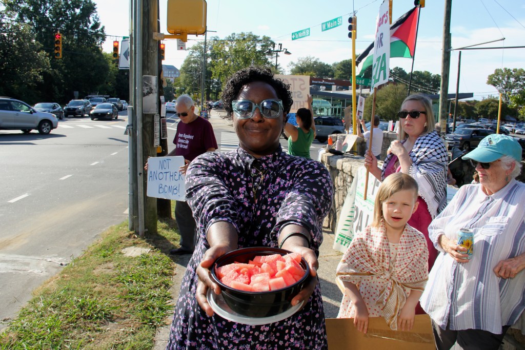 Jackie Morin offers watermelon to non-fasting protesters.
