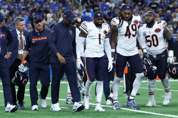 Bears cornerback Jaylon Johnson (1) is helped off the field after a play in the second quarter against the Lions at Ford Field on Sept. 14, 2025, in Detroit. (John J. Kim/Chicago Tribune)