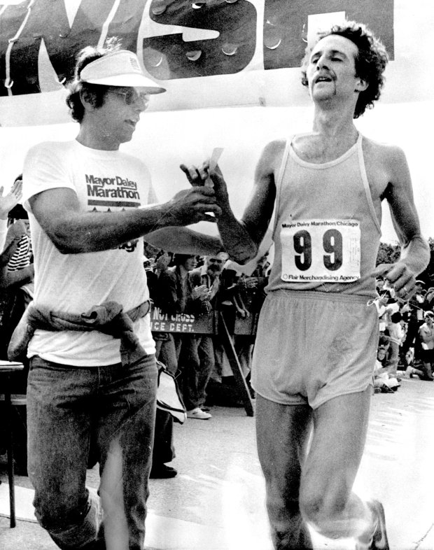 Dan Cloeter, 25, of Fort Wayne, Indiana, is welcomed by an official as he crosses the finish line near Buckingham Fountain to win the 1977 Mayor Daley Marathon on Sept. 25, 1977. (Michael Budrys/Chicago Tribune)
