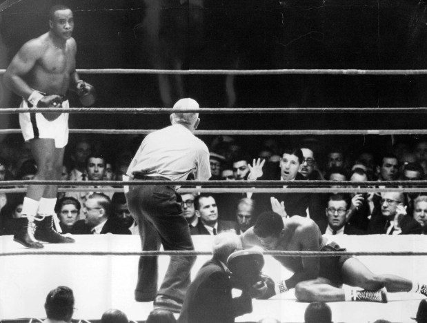 Timer Mike Murphy tolls the end of Floyd Patterson's reign as heavyweight champion as he counts Floyd out after 2:06 of the first round on Sept. 25, 1962, at Comiskey Park in Chicago. Patterson lost the title before a crowd of 18,894 to Sonny Liston, left, of Philadelphia. (Chicago Tribune historical photo)