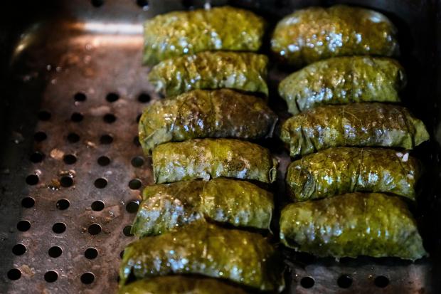 Dolmas, created with locally foraged grape leaves, are prepared in...