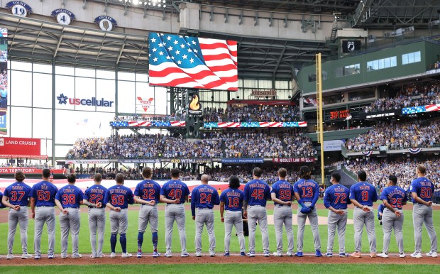 The Chicago Cubs stands for the national anthem before the...