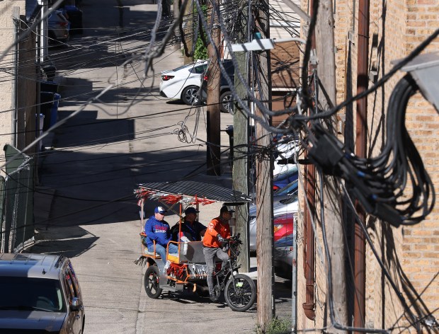 Cubs fans arrive to Wrigley Field in a pedicab for...