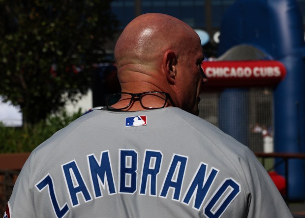 A Cubs fan rests his eyeglasses on his neck while...