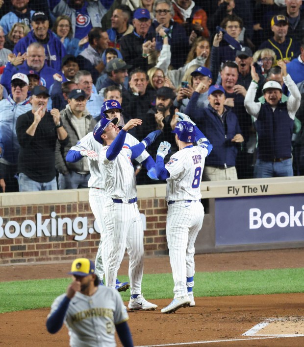 Cubs left fielder Ian Happ celebrates with teammates after hitting...