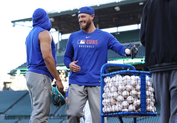 Cubs first baseman Michael Busch laughs as players warm up...