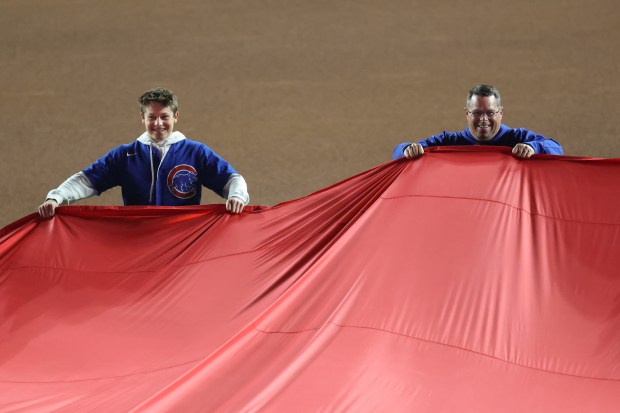 Fans hold an oversized U.S. flag during the national anthem...