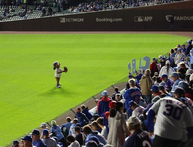 Cubs mascot Clark plays catch with a fan before Game...