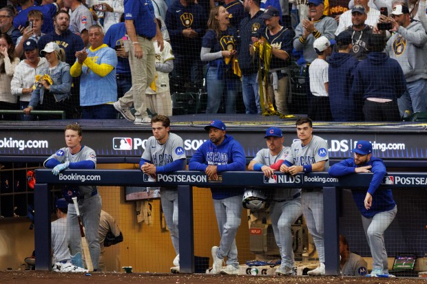 Cubs players watch as the Brewers celebrate their 3-1 victory...
