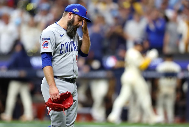 Chicago Cubs relief pitcher Andrew Kittredge walks to the dugout...