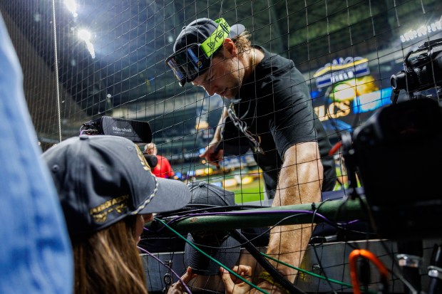 Brewers pitcher Trevor Megill gives a fan a hat after...