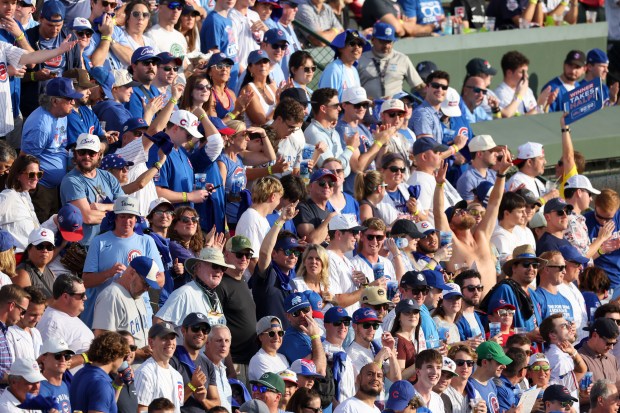 Fans cheer after the Cubs scored during the second inning...