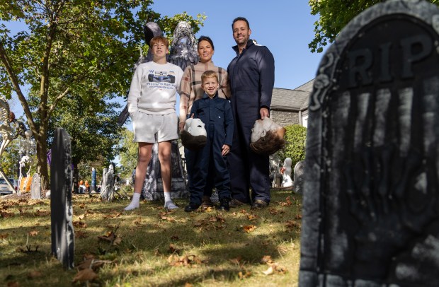 The Zimmerman's, from left, Mason, 14, Sabrina, Harrison, 7, and Evan pose, Oct. 9. 2025, in the Halloween decorated front yard of their home in Decatur, Indiana. The Zimmermans are popular on Tik Tok for their videos where Evan and Harrison dress as Michael Myers. Evan Zimmerman began cosplaying as Michael Myers in Halloween and went viral in 2019. (Dominic Di Palermo/Chicago Tribune)