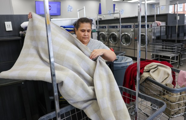 Tina Rosales folds laundry at Smart Wash Laundry, Oct. 22,...