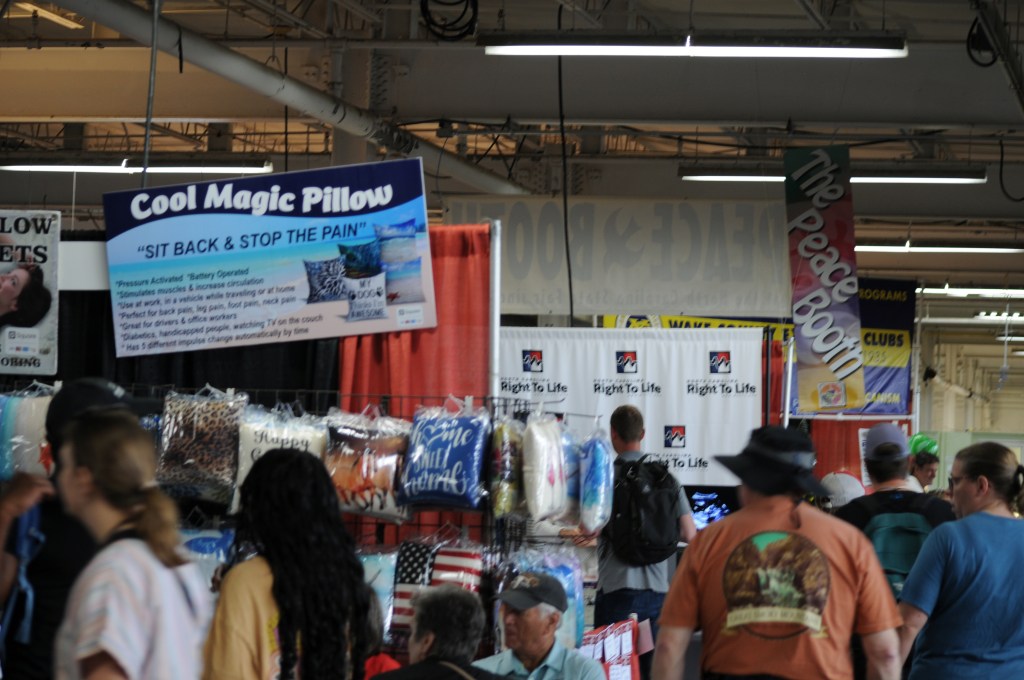 The Peace Booth sits amid all the other offerings in the fair’s white stucco Education Building.
