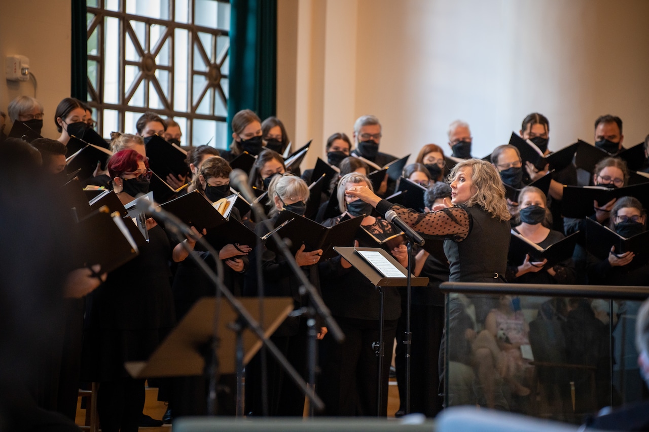 Members of the Portland Symphonic Choir, wearing face masks, sing Christmas music.