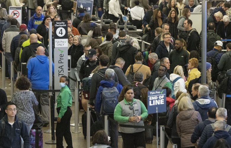 Travelers wait in a security line at SEA (Seattle-Tacoma International Airport) on Friday, November 17, 2023, the last Friday before Thanksgiving.  The airport is expected to be extremely crowded from now through the Thanksgiving weekend. 225522