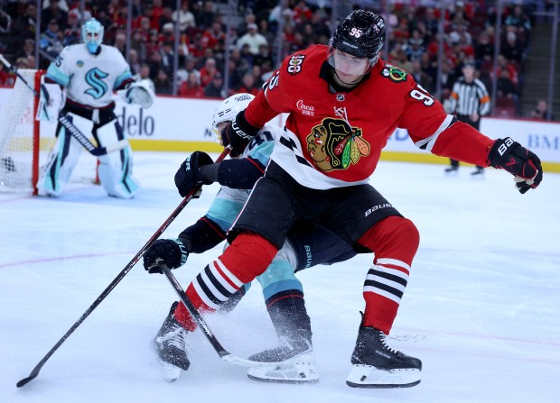 Chicago Blackhawks right wing Ilya Mikheyev (95) and Seattle Kraken defenseman Ryker Evans (41) get tangled up in the third period of a game at the United Center in Chicago on Nov. 20, 2025. (Chris Sweda/Chicago Tribune)