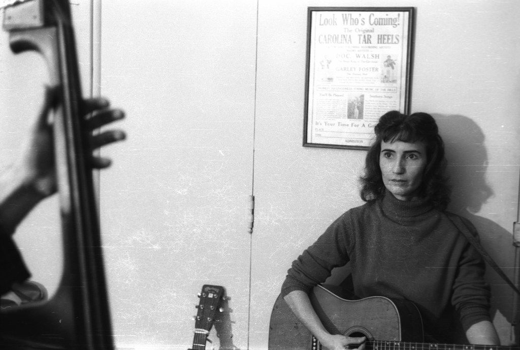 One of our house parties in Washington, DC, 1962. Hazel is sitting under an old flyer for the Carolina Tar Heels. Photo by Jeremy Foster; courtesy Alice Gerrard.