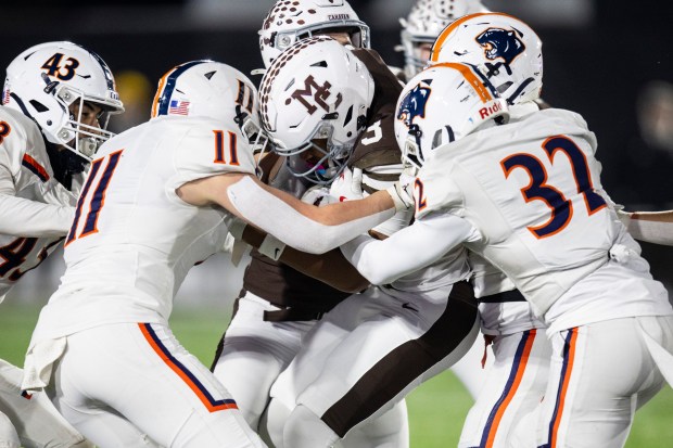 Oswego's Cade Cooney (11), Quinten Jackson Jr. (32) and teammates tackle Mount Carmel's Marshaun Thornton (3) during the Class 8A state championship game in DeKalb on Wednesday, Dec. 3, 2025. (Vincent D. Johnson / for the Daily Southtown)