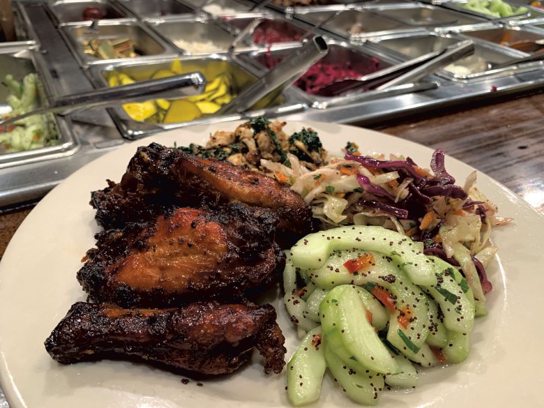 A plate of hot and cold bar selections, including Misty Knoll wings, at Stone Soup