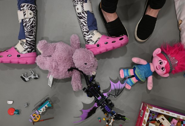 Everly Green, 8, lies next to her mother, Chrissy Green, as she reads to her at their home in Fort Collins on Dec. 18, 2025. (Photo by RJ Sangosti/The Denver Post)