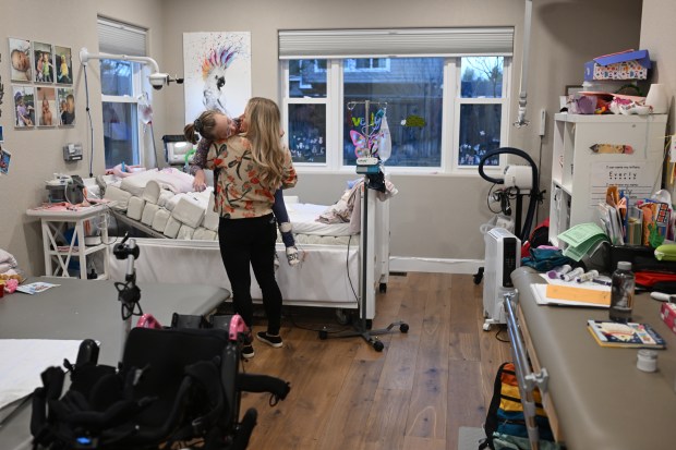 Chrissy Green lifts her daughter Everly, 8, out of bed at their home in Fort Collins on Dec. 18, 2025. (Photo by RJ Sangosti/The Denver Post)