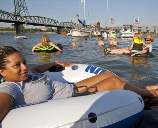 a group of people sitting in inner tubes and swimming in a river